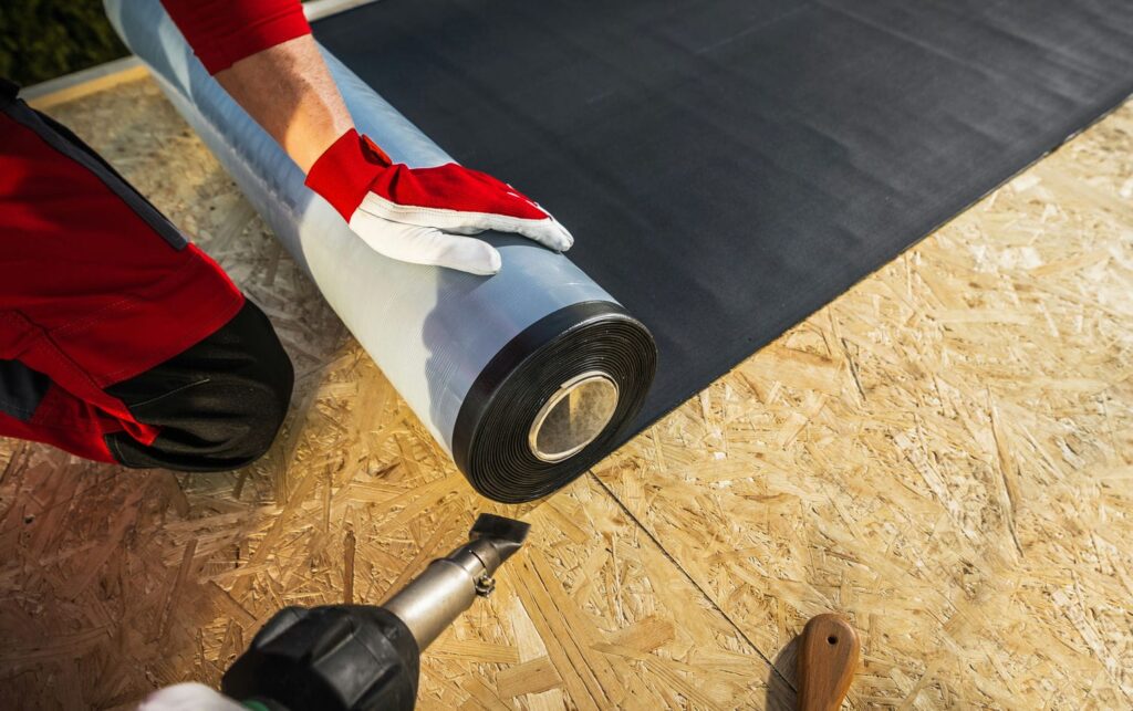roof worker installing construction membrane for energy step code compliance