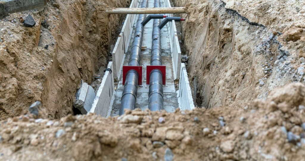 underground utility pipes being installed in trench